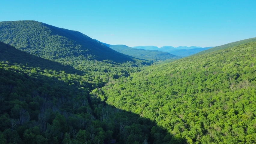 Aerial drone video footage of summer time in the Catskill Mountains in New York’s Hudson Valley. The Catskills are a sub-range of the Appalachian Mountains on the east coast of the United States. Royalty-Free Stock Footage #1074677861