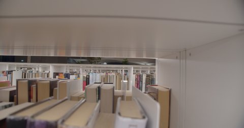 Helsinki , Helsinki , Finland - 02 05 2021: Empty modern library shelves at closing time, close up slider shot