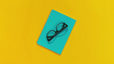 Notepad Glasses Pen and Sanitizer Appear Against an Orange Background