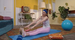Funny video of the caucasian woman sitting at the yoga mat and exercising during the eating pizza at home. Motivation and unhealthy lifestyle concept