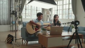 Asian Children Playing Guitar And Sing A Song While Streaming. The Children Is Broadcasting Live On The Internet. Professional Light Equipment
