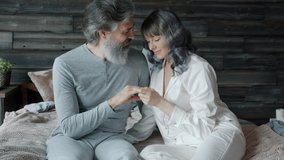 Loving couple mature husband and middle-aged wife are hugging caressing each other expressing tenderness sitting in bed together. Relationship and affection concept. - Powered by Shutterstock - Get 15% off with code: PIKWIZARD15