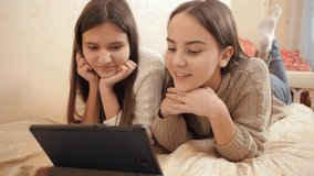 Two teenage girls chatting during educational video conference. Remote studying and communication from home