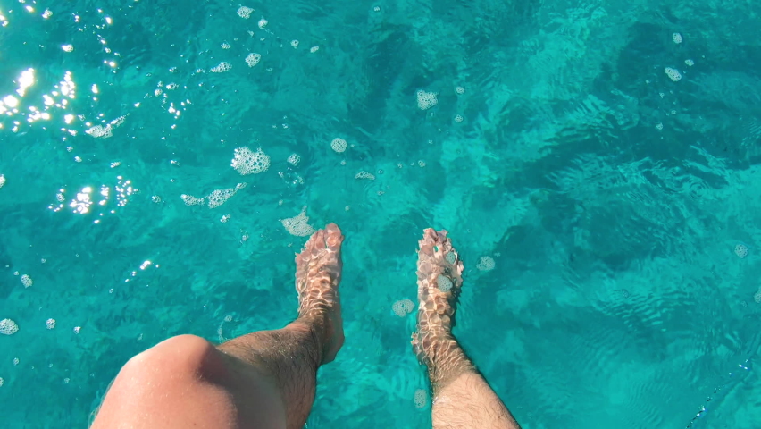 Slow motion - First person view of male legs splashing beautiful turquoise water | Shutterstock HD Video #1074691079
