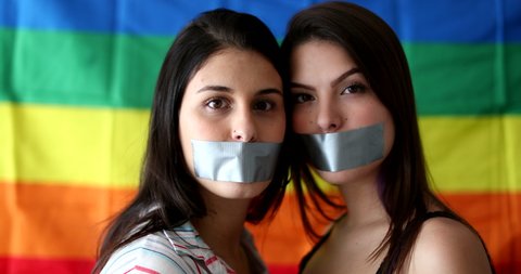 Two lesbian girlfriends with mouth duct taped unable to speak. LGBT censorship concept
