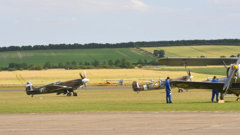 Duxford UK JULY, 11, 2015 World War 2 historic fighter planes take off in formation. Supermarine Spitfire fighter plane of Royal Air Force. Vintage 4K videos of WW2