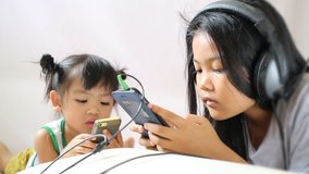 Two asian children to enjoy to play games from mobile phone