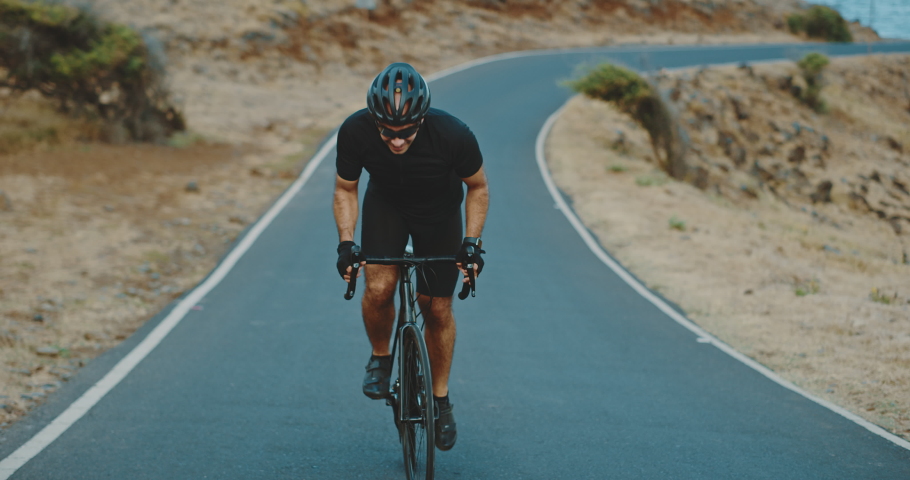Road biker cycling on scenic country road, intense workout and fitness, healthy active lifestyle | Shutterstock HD Video #1074702944