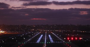 Cinematic sunset at airport, 4K travel footage. Scenic pink sunset with purple clouds in summer sky. Holiday vacation tourism concept video. Back view airplane with tourists landing at night airport