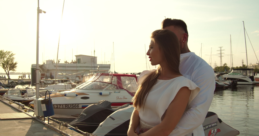 Romantic couple having date on embankment at sunset