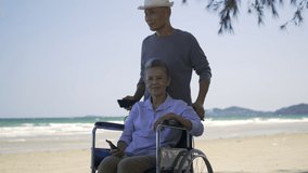 Happy Asian elderly woman in wheelchair and husband show vaccine pass while traveling at the beach, summer vacation, Retirement couple concept - Powered by Shutterstock - Get 15% off with code: PIKWIZARD15