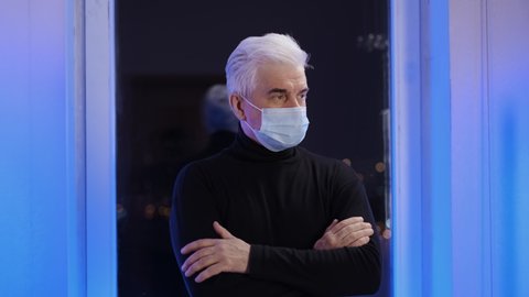 Masked businessman person in turtleneck in covid 19 looks at camera. Elderly grey hair people in coronavirus. White old man with face mask. Portrait of elder gray gentlemen in facemask under Covid-19.