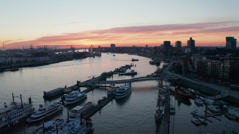 Aerial descending view of ferries and boats anchored in Hamburg port on river Elbe during sunset
