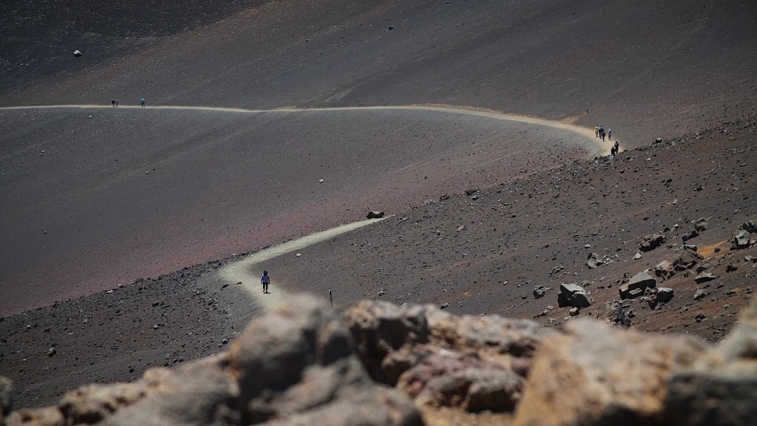 People walking through Haleakala Volcano Crater in Haleakalā National Park, Maui, Hawaii. Mid angle, parallax movement, slow motion, HD.