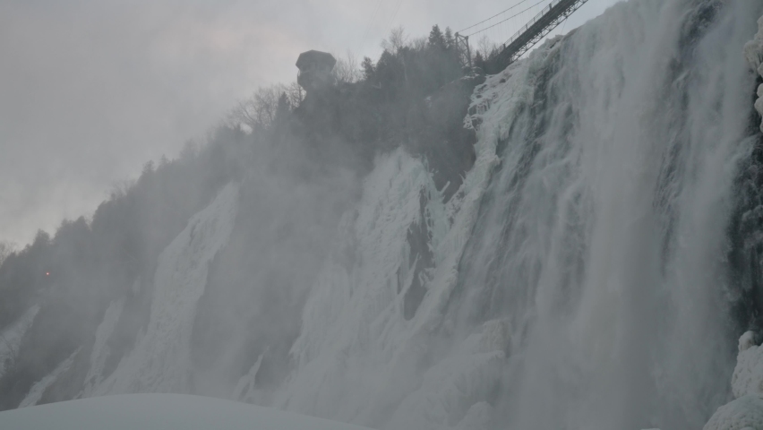 Famous Montmorency Falls - Cascades Flowing From Frozen Rocky Cliffs At Montmorency River In Quebec, Canada. - Panning Shot