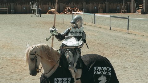 Ballarat , Australia - 04 18 2018: Slow motion shot of medieval knight with lance riding horse on joust tournament. Track shot.