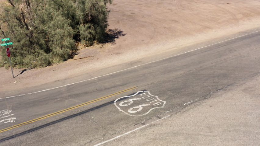 Large black SUV drives over Route 66 paint markings on famous highway