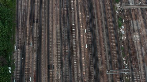Pan up drone shot from expansive railway train tracks to London Skyline