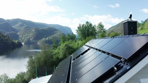 Solar panel installation on private countryside house in western Norway - Forwarding closeup of panels with nature background