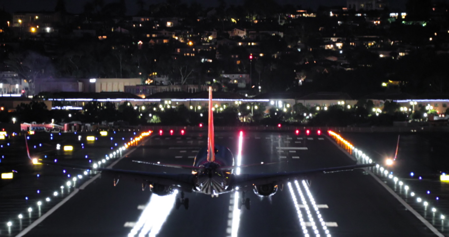 Airport view at night, 4K footage. Back view of airplane landing on runway with nigh signal lights on. Cinematic travel and tourism footage. Domestic or international travels, USA to Europe or China Royalty-Free Stock Footage #1074750218