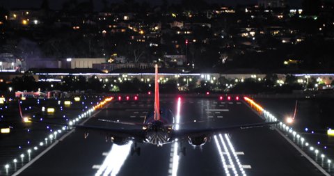 Airport view at night, 4K footage. Back view of airplane landing on runway with nigh signal lights on. Cinematic travel and tourism footage. Domestic or international travels, USA to Europe or China