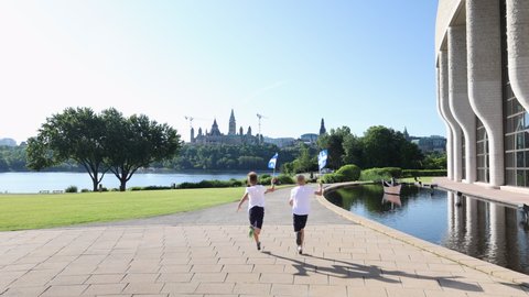 Boys run towards the Canadian parliament with Quebec flags