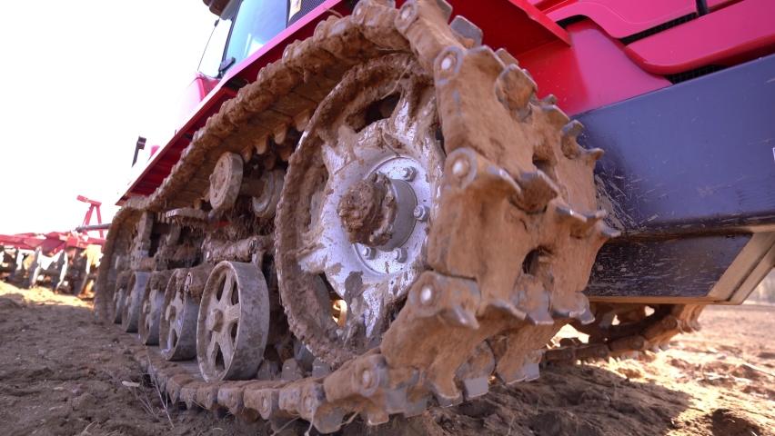Crawler tracks of a plowing tractor and a field in early spring, a plowed field for crops, close-up,