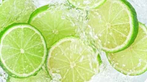 Super Slow Motion Shot of Lime Slices Falling Into Water Whirl at 1000 fps.