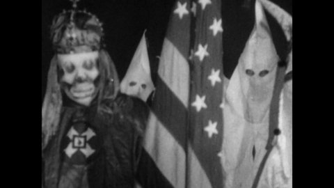 1915 Stone Mountain, GA. Grand Wizard of the Ku Klux Klan performs Initiation Rites for KKK Candidate. With Left hand on Bible, the new Member is Blessed with American Flag. 4K Scan of Archival Film