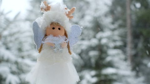 Winter angel on a snowy tree. White snow angel. Christmas symbol.