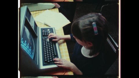 1980s Cupertino, CA. Young Kids type on Vintage Computer Keyboards. Young Girl inputs on Macintosh Apple Computer. 4K Overscan of Vintage Archival 16mm Film Print