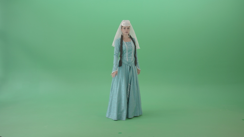 Caucasian Girl spinning in Georgian dance. A girl, dressed in traditional blue Georgian dress, performs on a green screen backdrop.