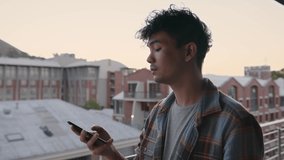 Mixed race male listening to music with earphones while texting on mobile phone