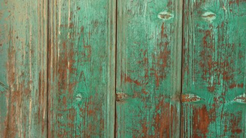 Closeup view 4k video footage of green and brown painted old vintage weathered texture of wooden gates or doors in countryside