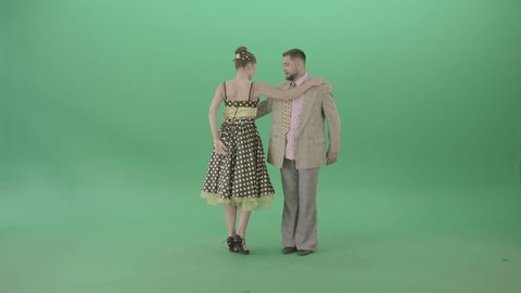 Amazing couple dance Lindy Hop and Rock and Roll. The man in a nice suit and woman in a nice black and yellow polka dot dress performing boogie-woogie dance moves on green screen background. 