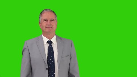 Chroma-key footage of an elderly businessman in  a gray suit looking at the camera