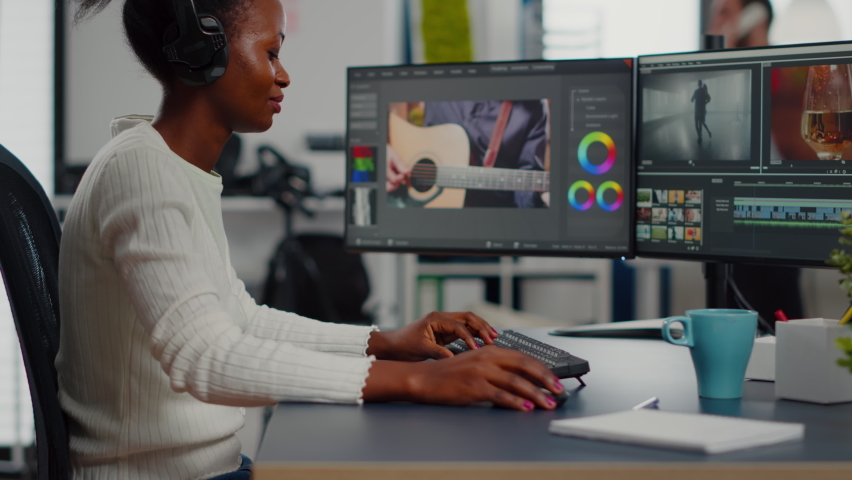 Black woman video editor editing new project film montage sitting in modern creative agency office. Content creator in digital multimedia company processing movie with post production software | Shutterstock HD Video #1074781667