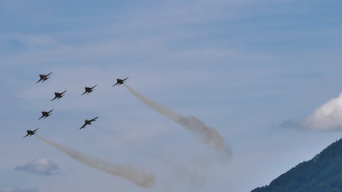 Mollis Switzerland AUGUST, 16, 2019 Huge formation of cold war era military fighter jets in flight. Hawker Hunter Mk 68 trainer in Tiger color scheme and Northrop F-5 of Swiss Air Force 