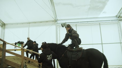 Prague , Czech Republic - 01 17 2021: Stuntman with ax jumps off horse to attack actors on rehearsal platform, Slowmo