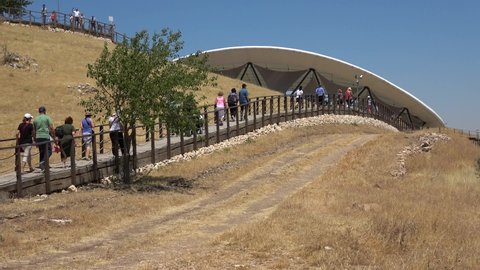 Gobeklitepe, Sanliurfa, Turkey - 15thth of June 2021: 4K Group of people walk to the Gobekli Tepe archaeological site
