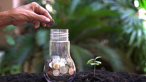 Hand old people holding money put jar or saving and Investment after retirement and elderly.  Saving for investment real estate home