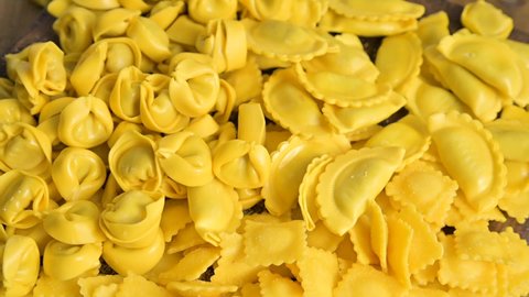 Fresh homemade pasta. Different Tartollini with cheese or meat for cooking in broth, different shapes. Traditional dish for celebrations in italy, Emilia Romagna region. Vertical video,social networks