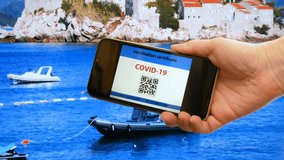Vaccination passport on a mobile phone allowing travel in hand on Sveti Stefan, Budva, Montenegro background. Vaccination against the coronavirus Covid 19.Imunity or Health passport - Powered by Shutterstock - Get 15% off with code: PIKWIZARD15