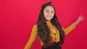 Extremely happy young woman dancing happily, doing very kawaii choreography, enjoying Japanese music, fast paced, moving in dynamic winning dance. Video in a studio with a red background