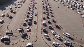 Aerial shot of 1000’s of people in cars waiting in line at a drive-through testing site to be tested for Coronavirus or to receive the vaccine. - Powered by Shutterstock - Get 15% off with code: PIKWIZARD15