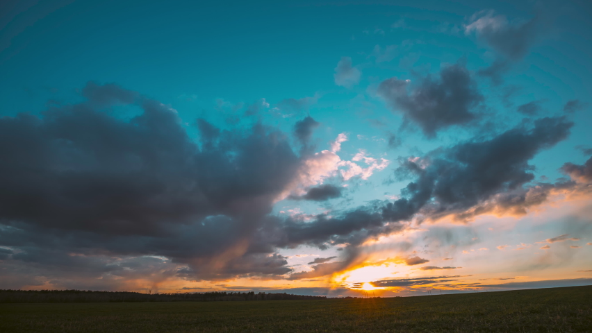 4K Countryside Rural Field Landscape With Young Green Wheat Sprouts In Spring Springtime Cloudy Day. Agricultural Field. 4K time-lapse, timelapse. Sunset Evening Time. sunset video, horizon sunset. Royalty-Free Stock Footage #1074825599