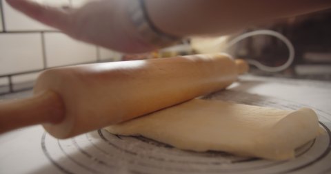 Close up hands of bakery Chef preparing applying flour and kneading roll out dough with a rolling pin on the table, Ingredients and preparation stages for cooking making bread cake at kitchen