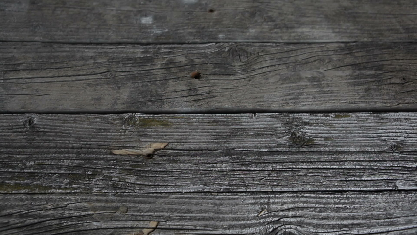 Man puts handcuffs on an old wooden table. Looping. Police handcuffs on old wooden boards.
