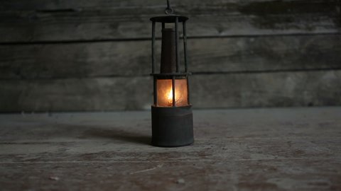 An old kerosene lamp in a wooden house. Burning kerosene lamp. Looping.
