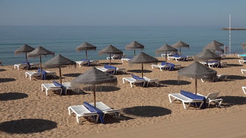 Empty sunbeds on beach symbolizing crisis in tourism sector in Southern Europe. Portugal eases lockdown restrictions and prepares for Summer holiday.
